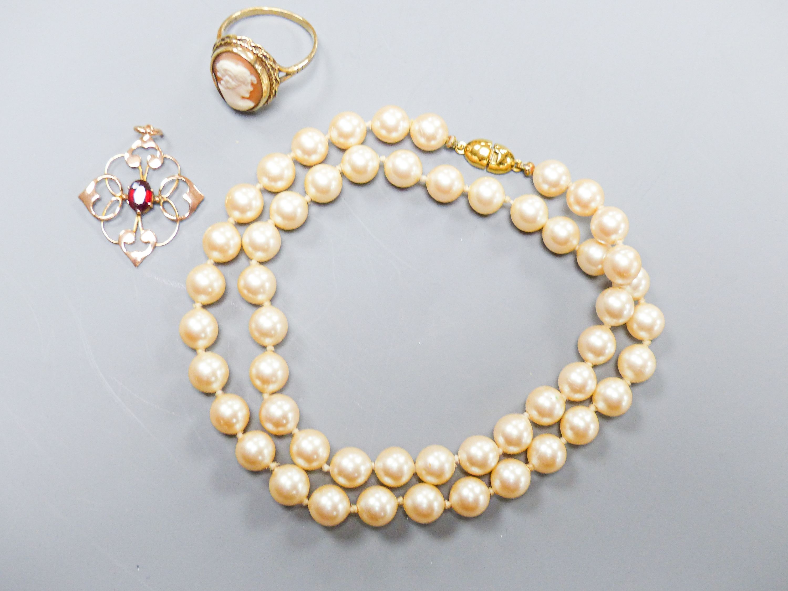 A 9ct gold and cameo shell oval ring, a 9ct and garnet set pendant and a simulated pearl necklace.
